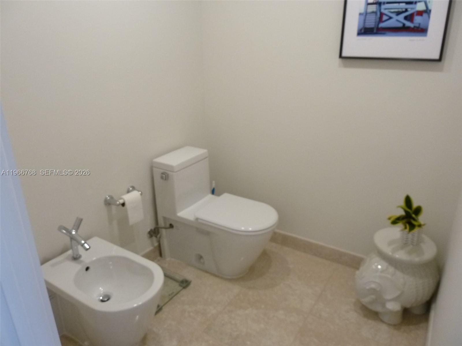 400 Alton Road, Unit 905 Miami Beach, FL 33139 - Photo 19 of 30 a white toilet sitting next to a bathroom sink
