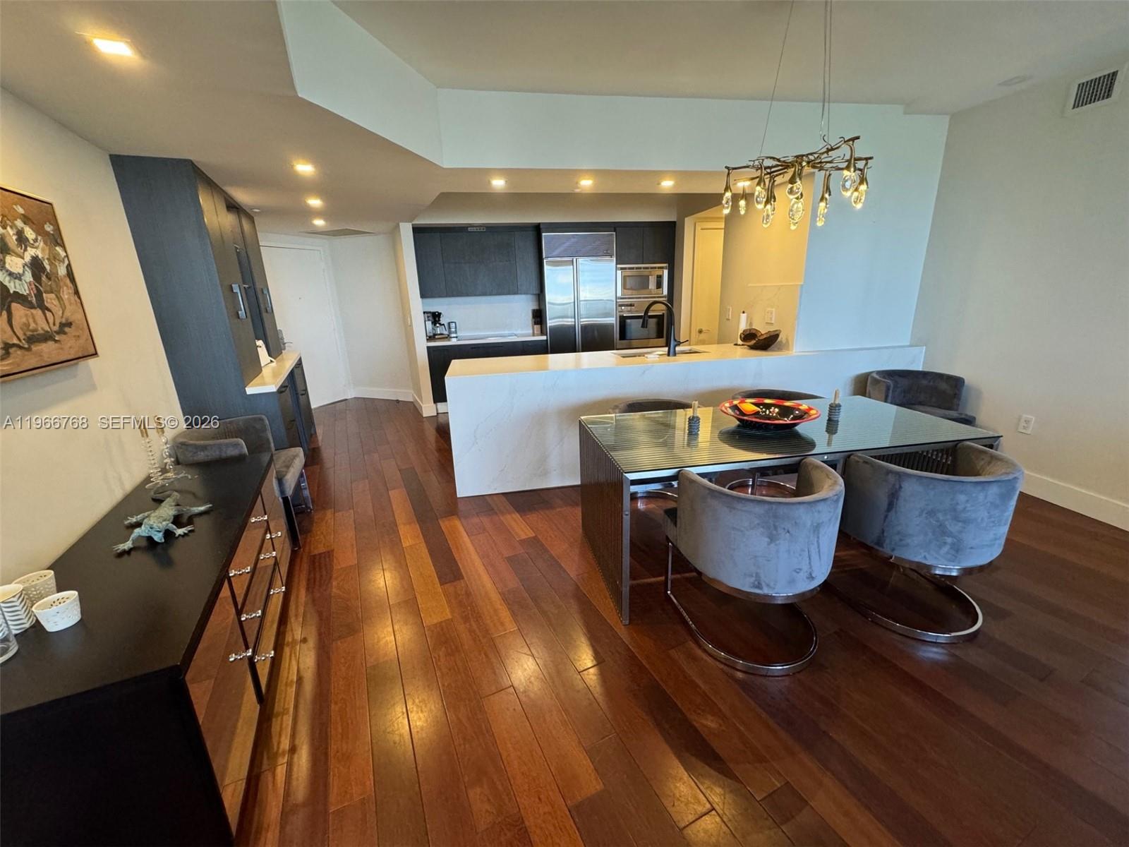 400 Alton Road, Unit 905 Miami Beach, FL 33139 - Photo 5 of 30 a dining room with furniture and a chandelier