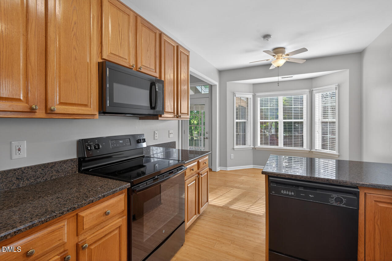 5325 Bartram Place Raleigh, NC 27617 - Photo 12 of 31 a kitchen with stainless steel appliances granite countertop a stove and a microwave