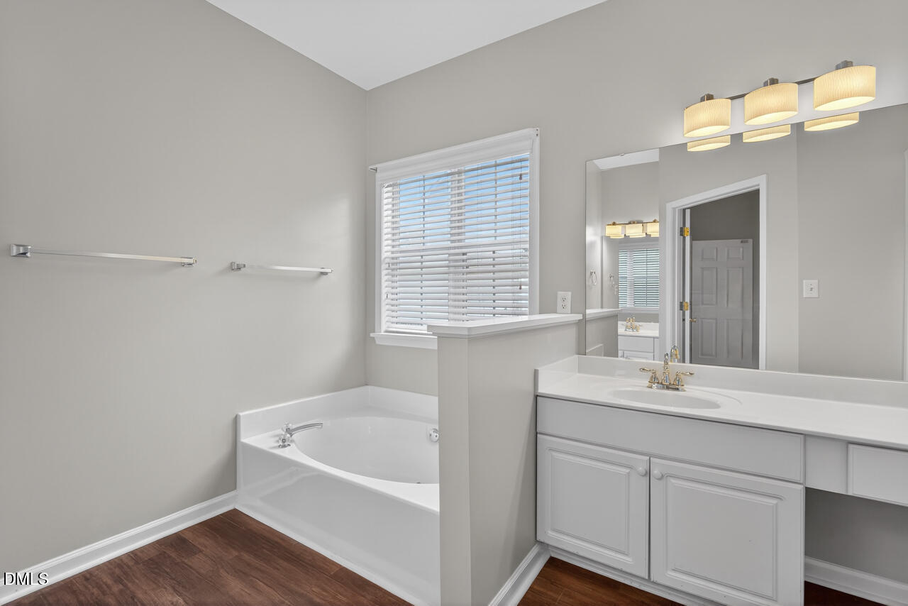 5325 Bartram Place Raleigh, NC 27617 - Photo 17 of 31 a bathroom with a tub sink and mirror