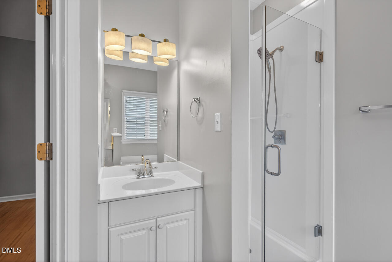 5325 Bartram Place Raleigh, NC 27617 - Photo 19 of 31 a bathroom with a shower sink and mirror