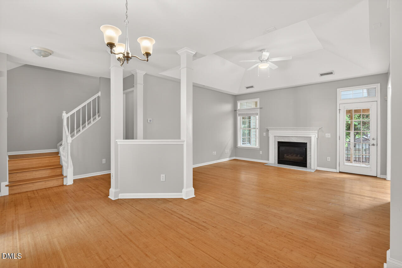 5325 Bartram Place Raleigh, NC 27617 - Photo 3 of 31 a view of an empty room with wooden floor fireplace and a window