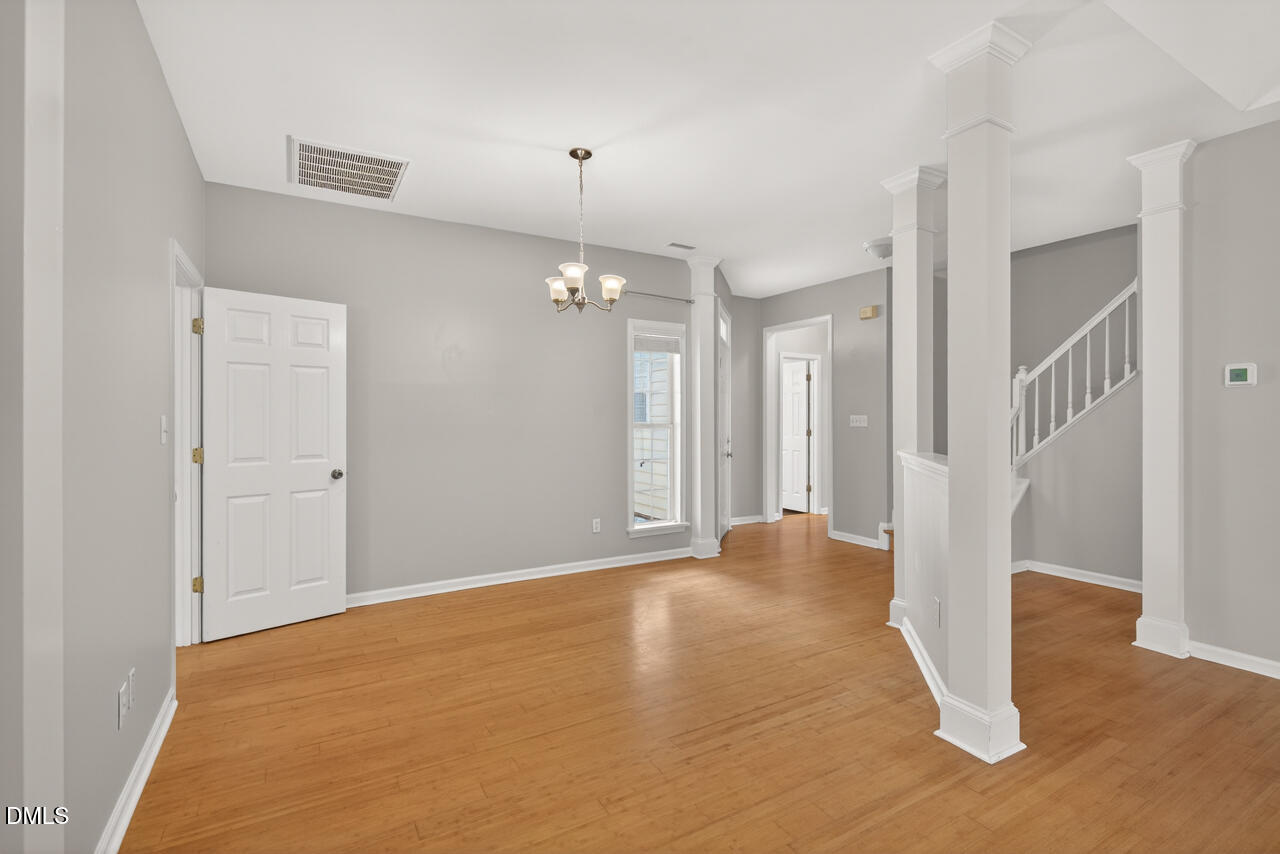 5325 Bartram Place Raleigh, NC 27617 - Photo 4 of 31 a view of an empty room with wooden floor and a ceiling fan