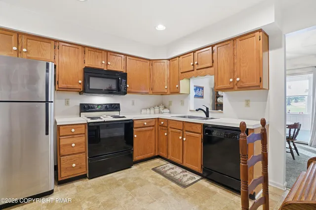 a kitchen with stainless steel appliances granite countertop a refrigerator stove microwave and sink