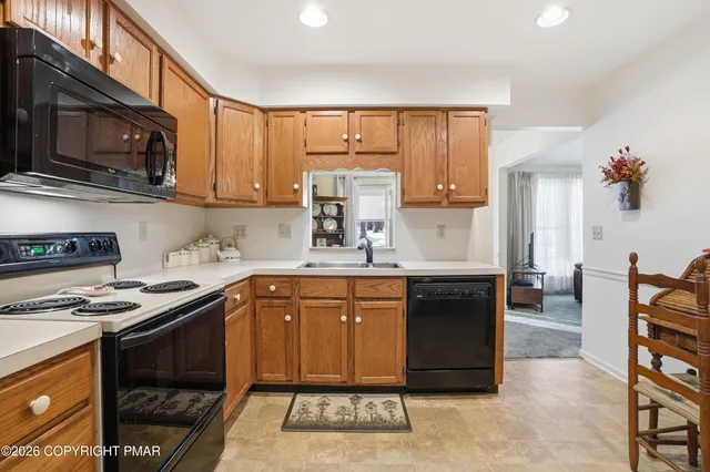 a kitchen with stainless steel appliances granite countertop a stove a sink dishwasher and cabinets with wooden floor
