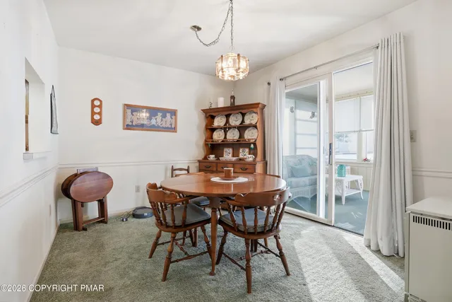 a view of a dining room with furniture and chandelier