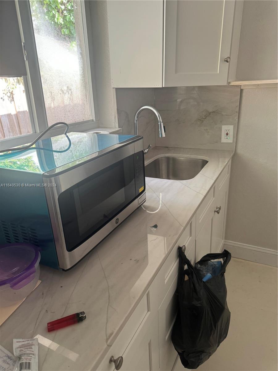 655 Northeast 80th Street Miami, FL 33138 - Photo 13 of 19 a kitchen with a sink and a microwave
