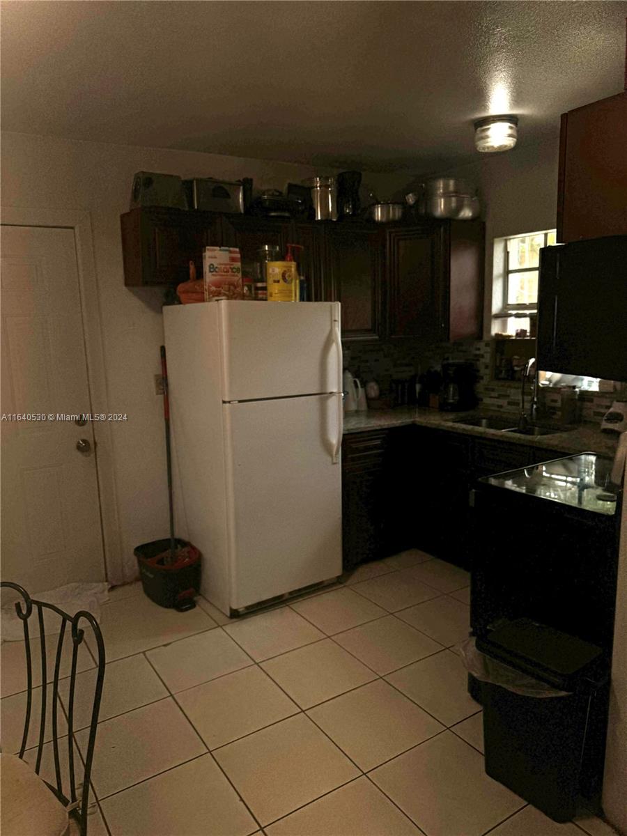 655 Northeast 80th Street Miami, FL 33138 - Photo 16 of 19 a kitchen with a sink a refrigerator and a stove