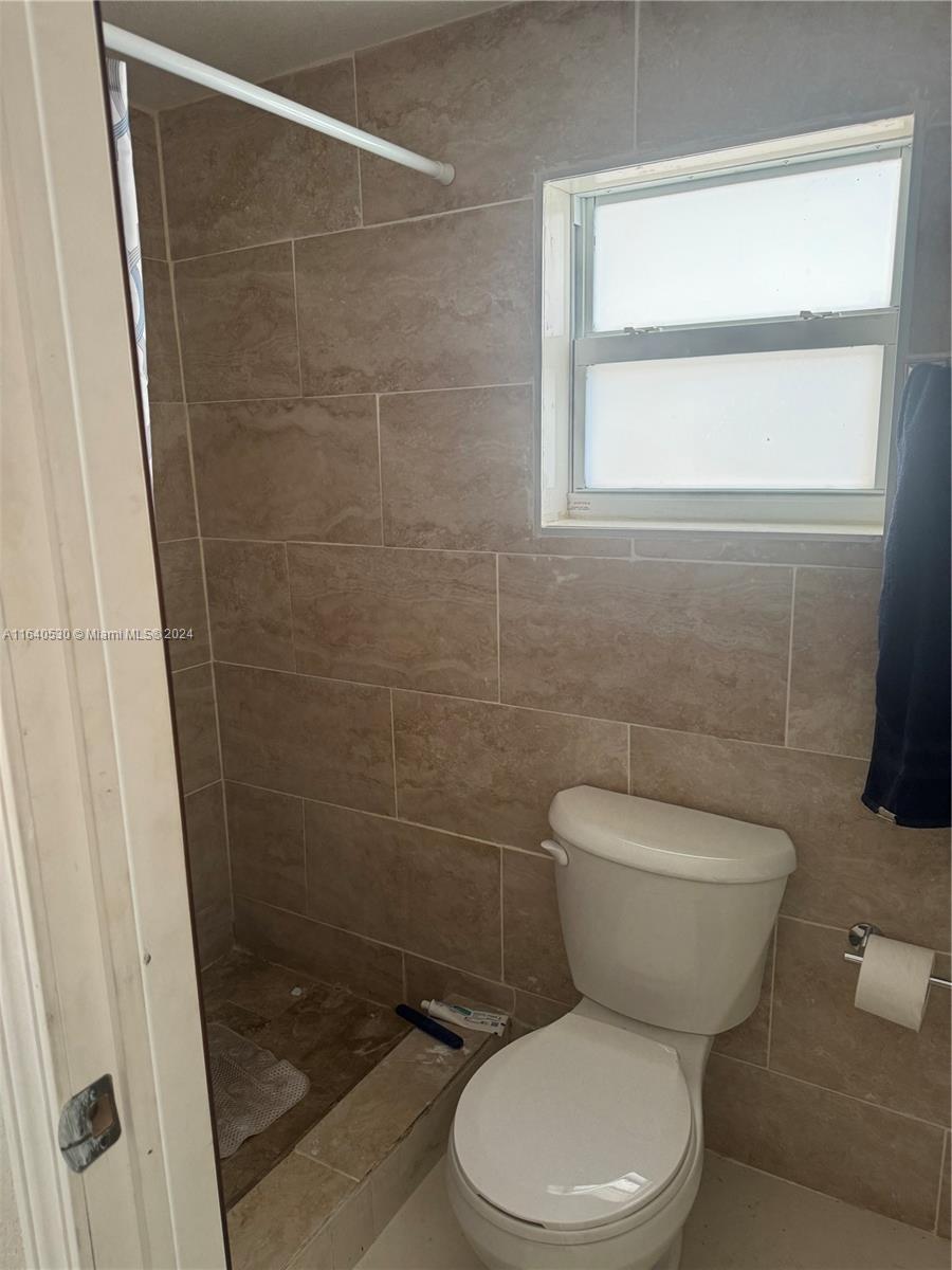 655 Northeast 80th Street Miami, FL 33138 - Photo 10 of 19 a white toilet sitting in a bathroom next to a window