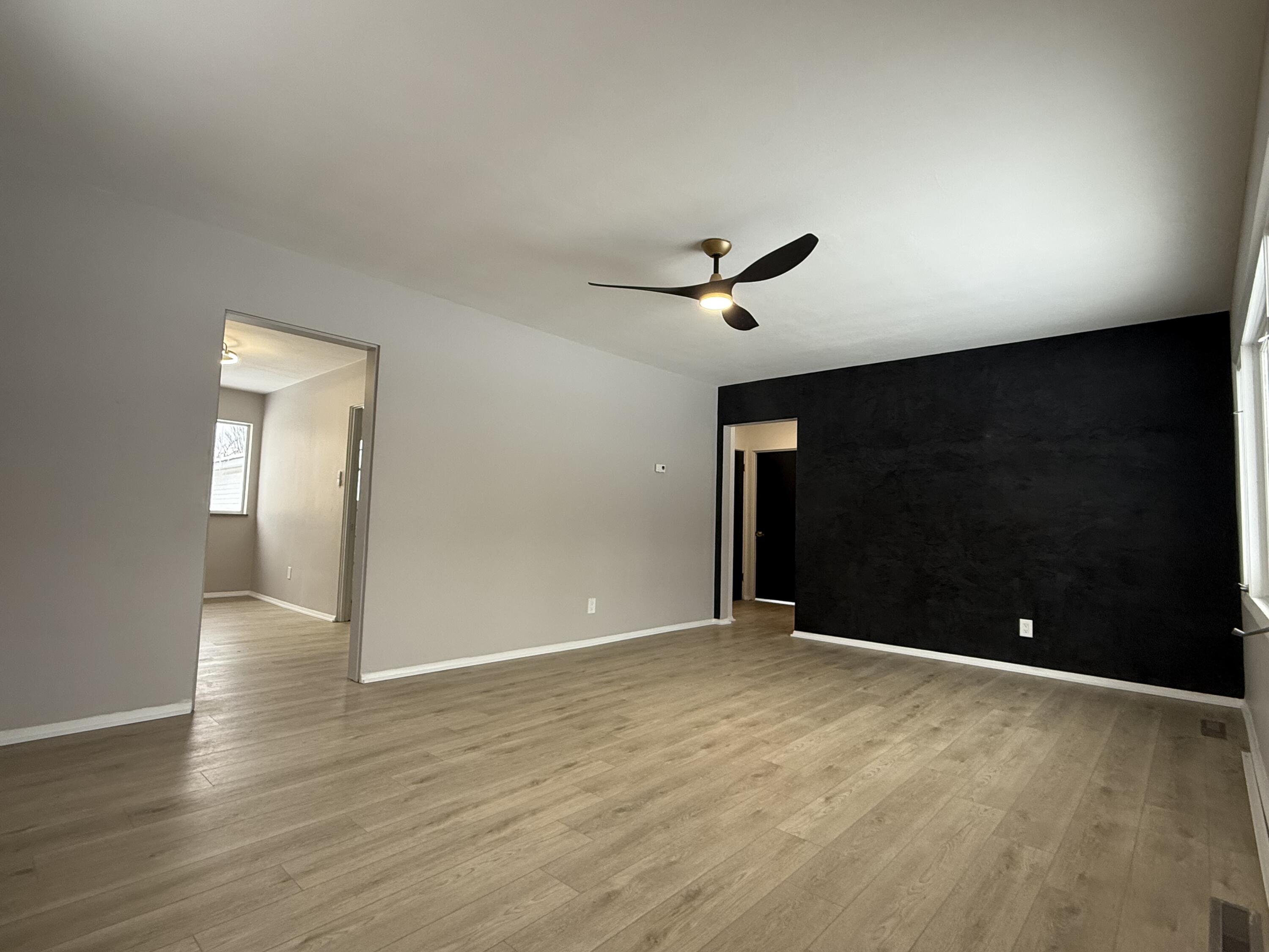 7008 Baring Avenue Hammond, IN 46324 - Photo 4 of 22 a view of an empty room with wooden floor and a ceiling fan