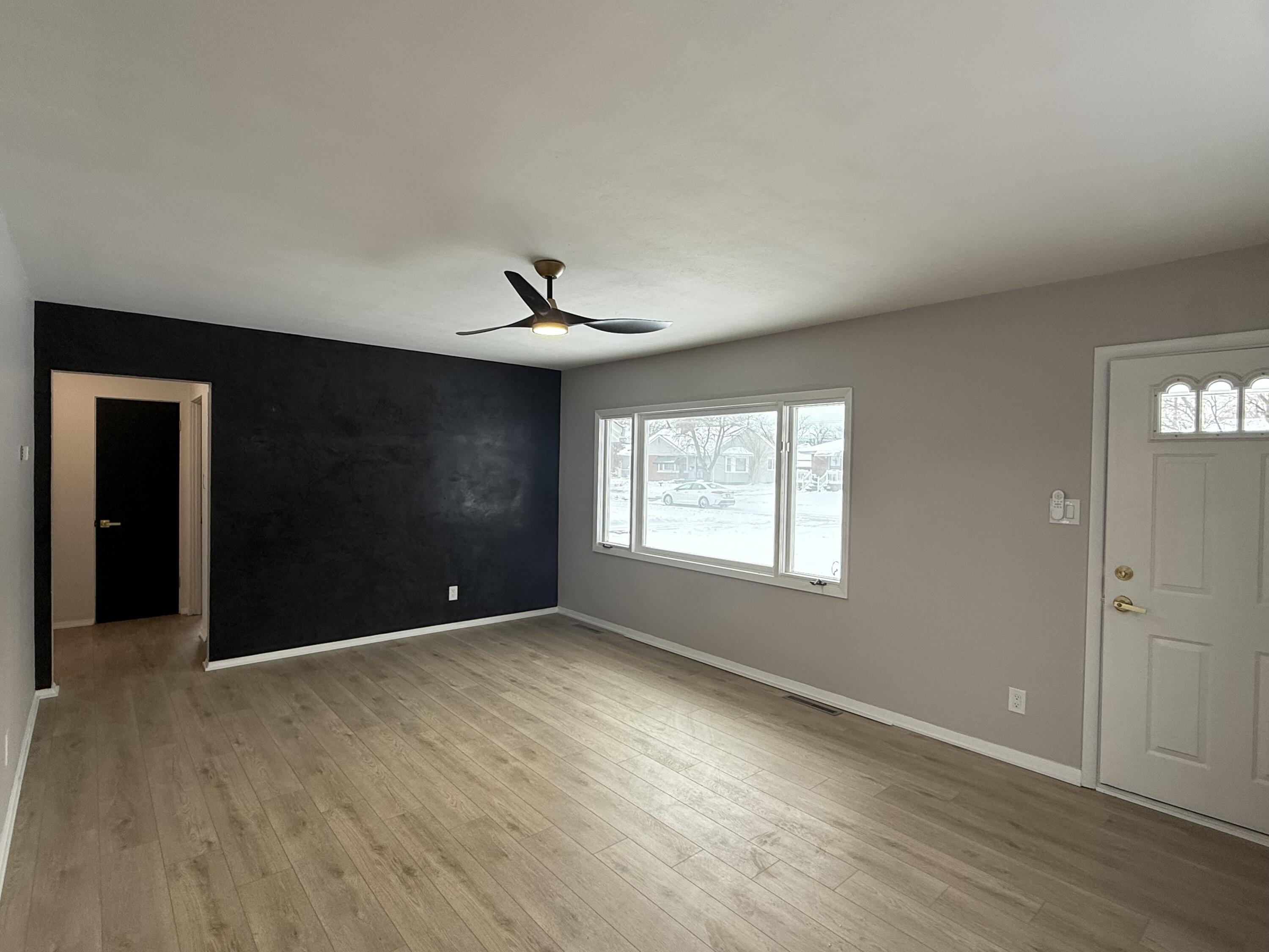 7008 Baring Avenue Hammond, IN 46324 - Photo 5 of 22 a view of an empty room with window and wooden floor