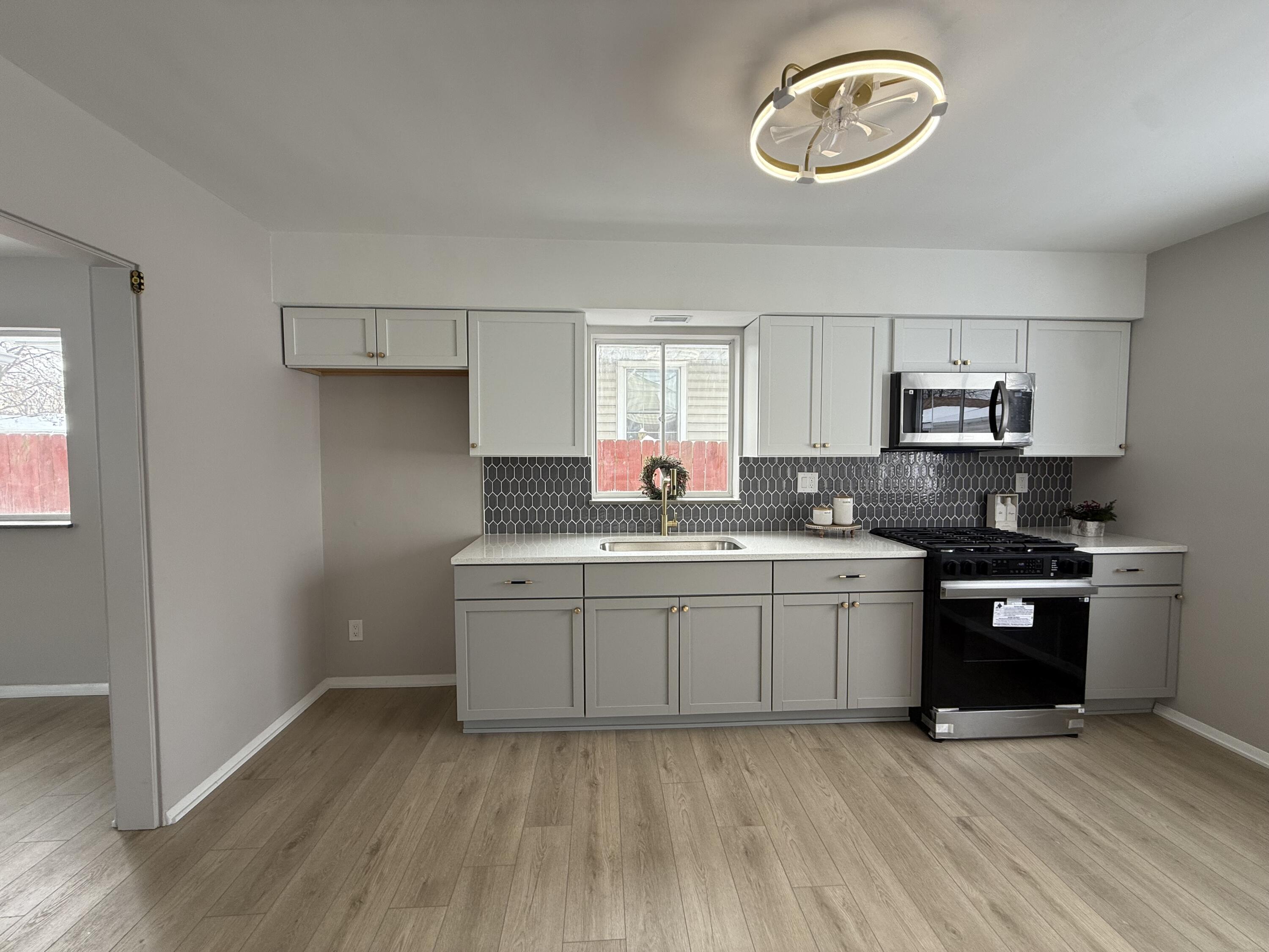7008 Baring Avenue Hammond, IN 46324 - Photo 6 of 22 a kitchen with stainless steel appliances granite countertop a stove a sink and a refrigerator
