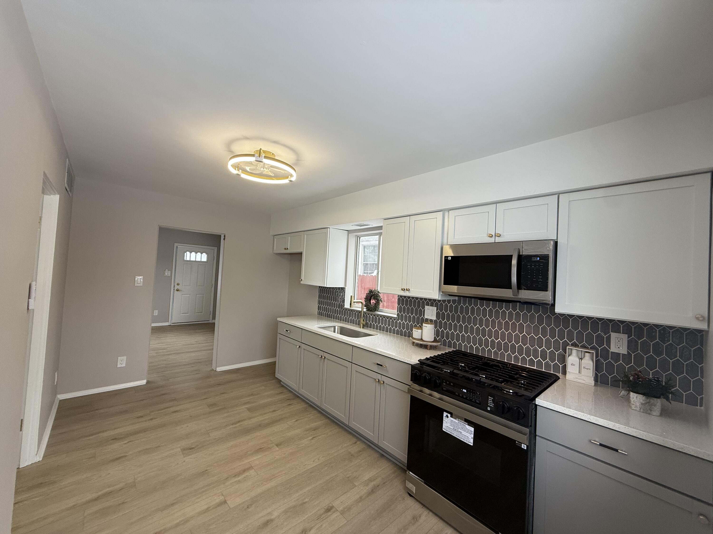 7008 Baring Avenue Hammond, IN 46324 - Photo 10 of 22 a kitchen with a sink stove and microwave