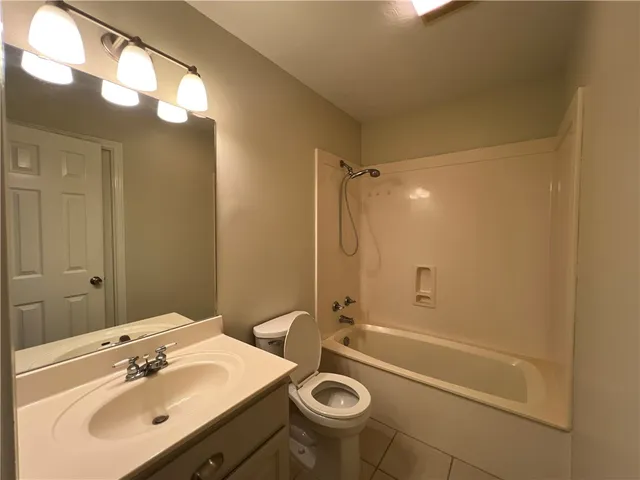 a bathroom with a sink a mirror a toilet and shower