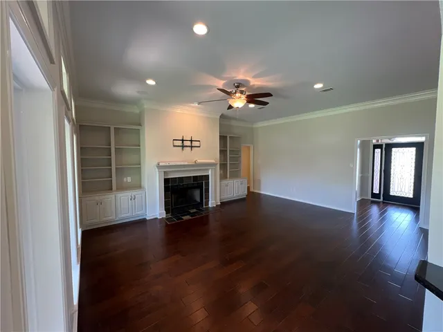 an empty room with wooden floor and fireplace
