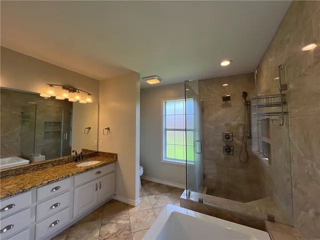 a bathroom with a granite countertop sink mirror and shower