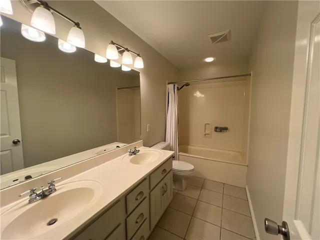 a bathroom with a double vanity sink mirror and shower