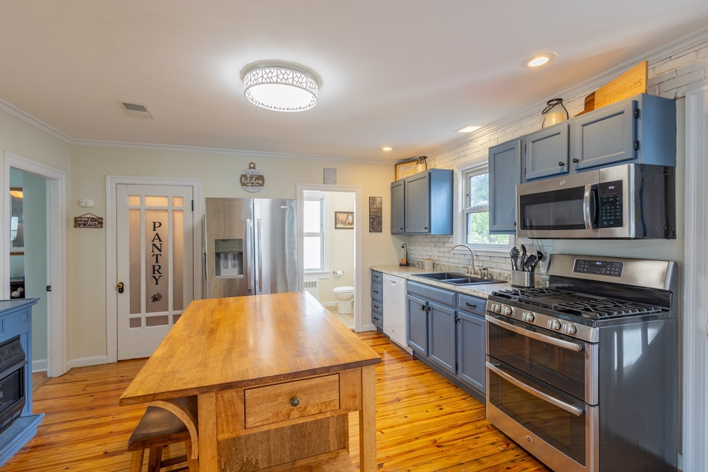 137 Papineau Avenue Woonsocket, RI 02895 - Photo 6 of 33 a kitchen with kitchen island granite countertop a stove and a sink