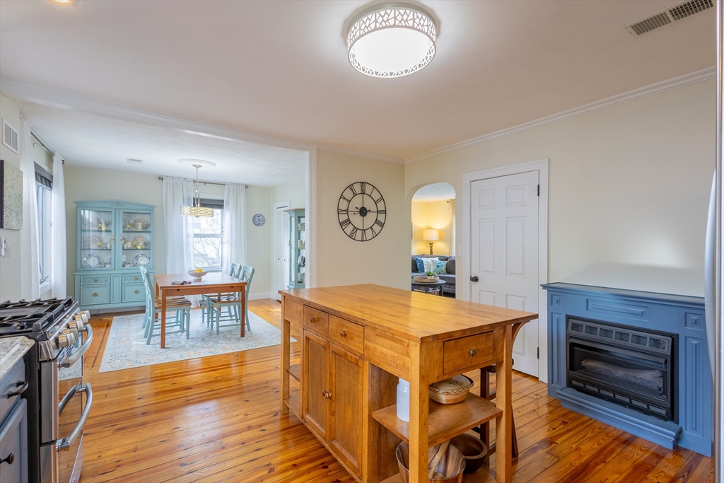 137 Papineau Avenue Woonsocket, RI 02895 - Photo 9 of 33 a dining hall with stainless steel appliances granite countertop a stove oven a dining table and chairs with wooden floor