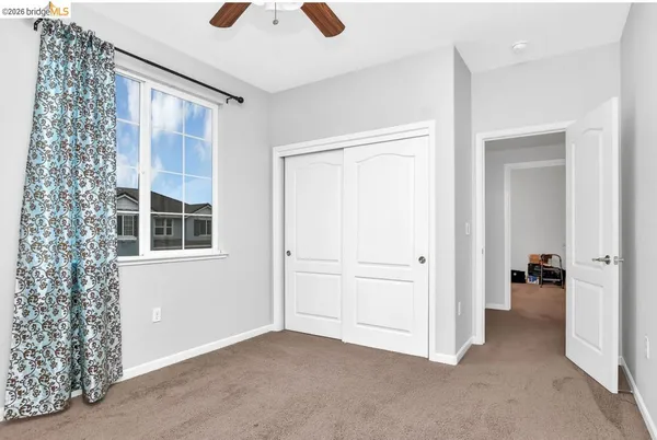 an empty room with closet and windows