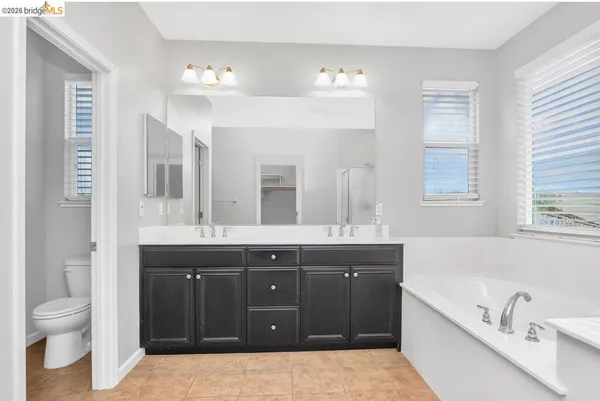 a spacious bathroom with a granite countertop sink and a bathtub