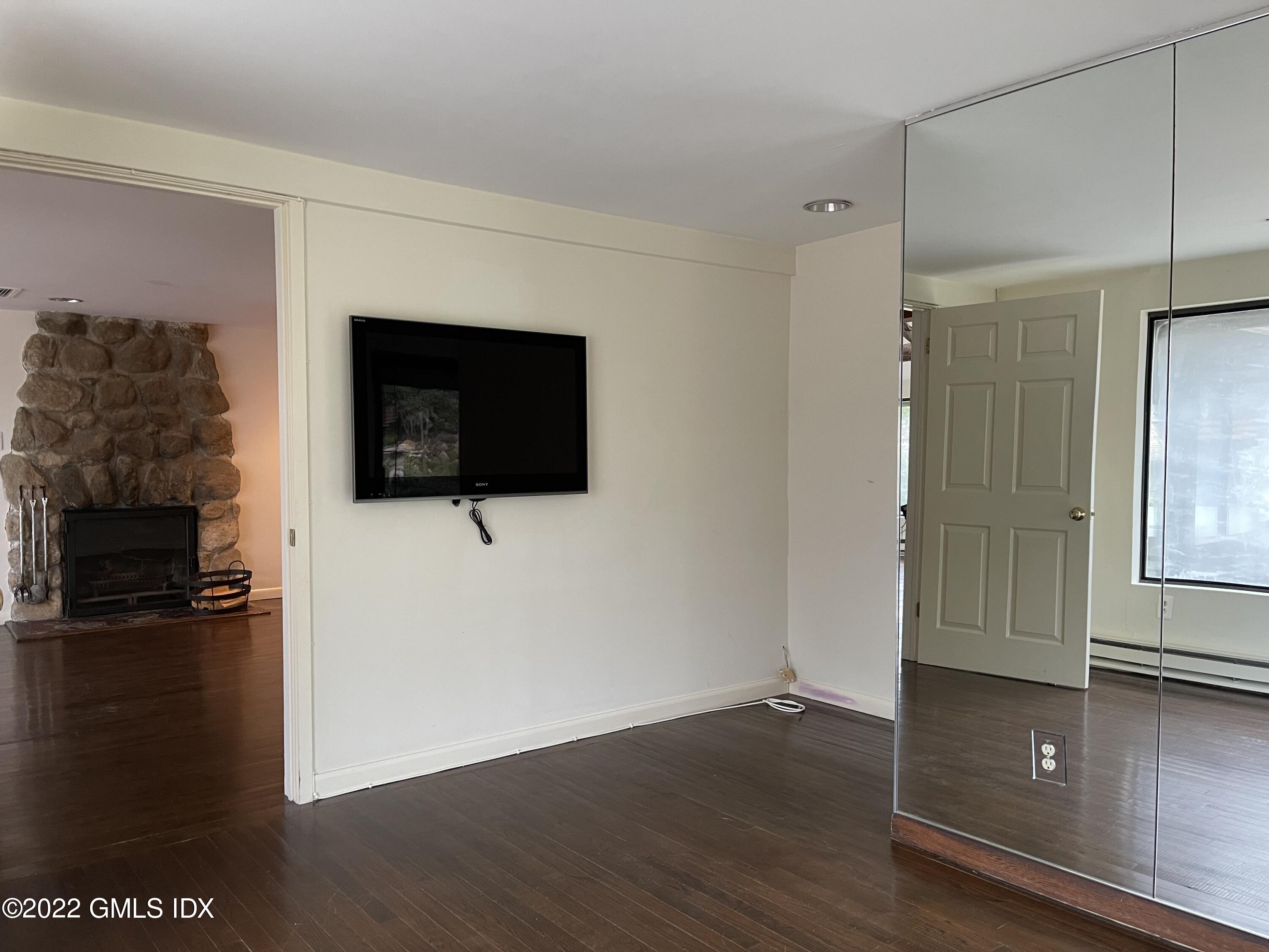 331 Stanwich Road Greenwich, CT 06830 - Photo 10 of 28 a living room with a flat screen tv and a fireplace