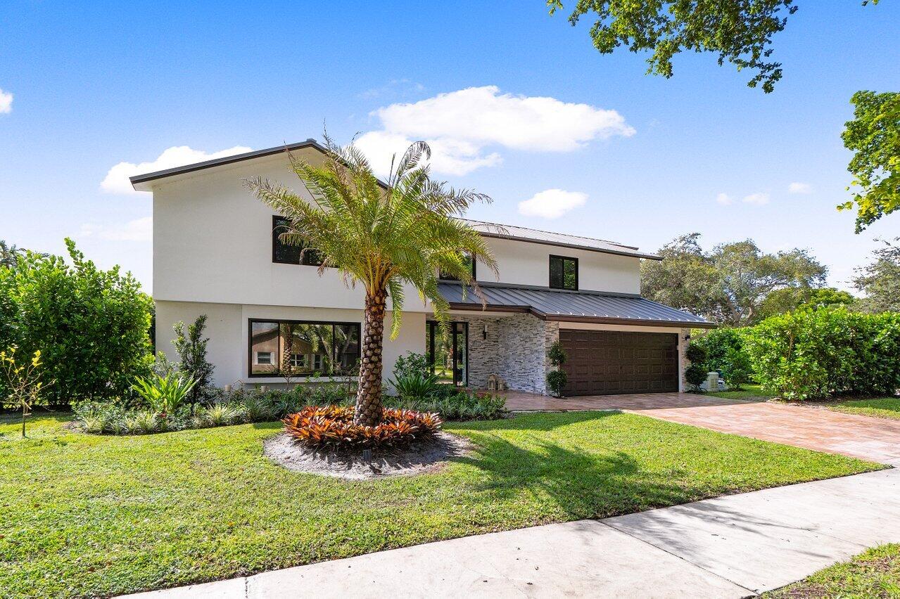 2296 Northwest 36th Street Boca Raton, FL 33431 - Photo 3 of 70 a front view of a house with a garden and yard