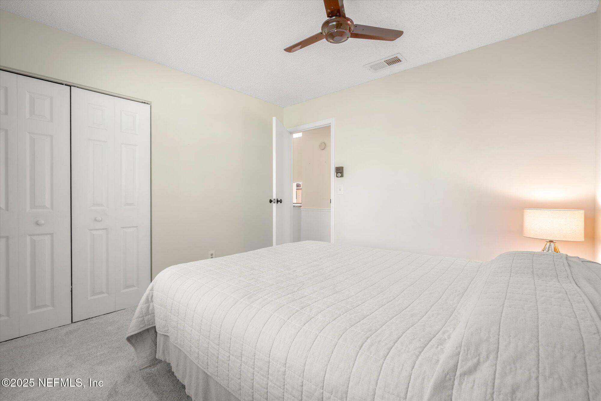 904 San Jose Road St. Augustine, FL 32086 - Photo 12 of 31 a bedroom with a bed and a lamp