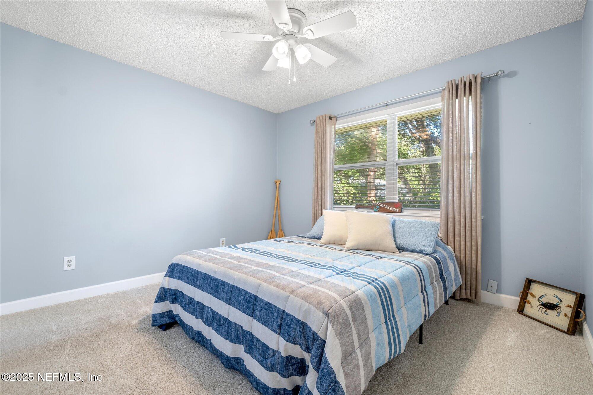 904 San Jose Road St. Augustine, FL 32086 - Photo 14 of 31 a bedroom with a bed and a chandelier