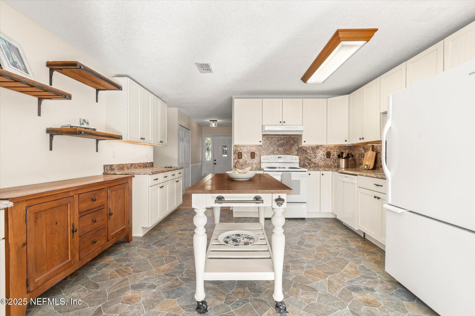 904 San Jose Road St. Augustine, FL 32086 - Photo 5 of 31 a kitchen with stainless steel appliances granite countertop a sink a stove a refrigerator and cabinets