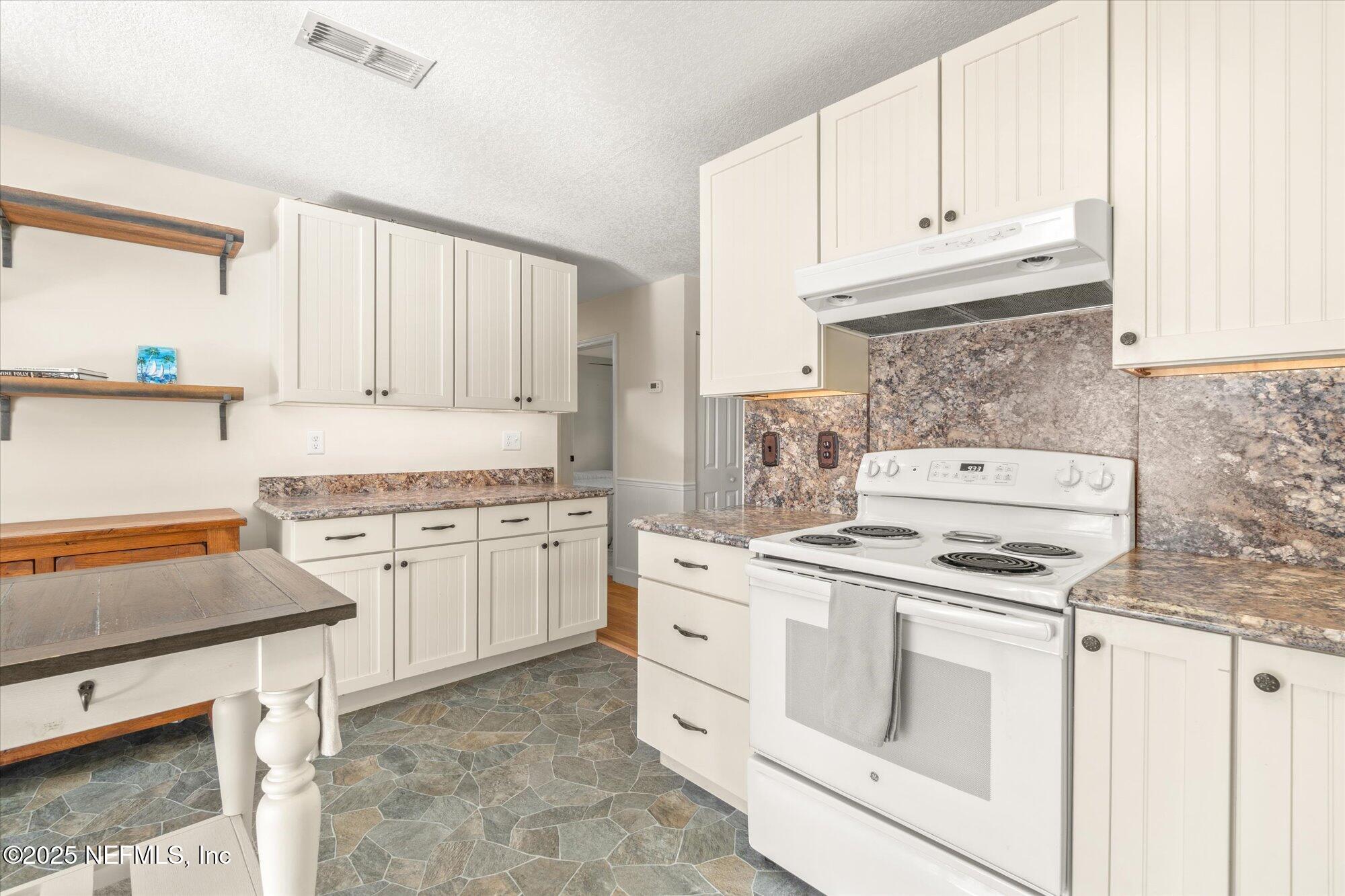 904 San Jose Road St. Augustine, FL 32086 - Photo 9 of 31 a kitchen with granite countertop white cabinets and white appliances