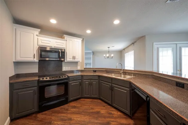 a kitchen with sink a microwave and cabinets