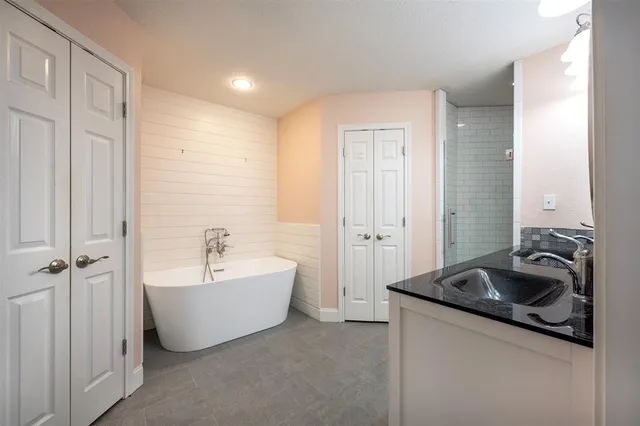 a bathroom with a bathtub sink a window and shower