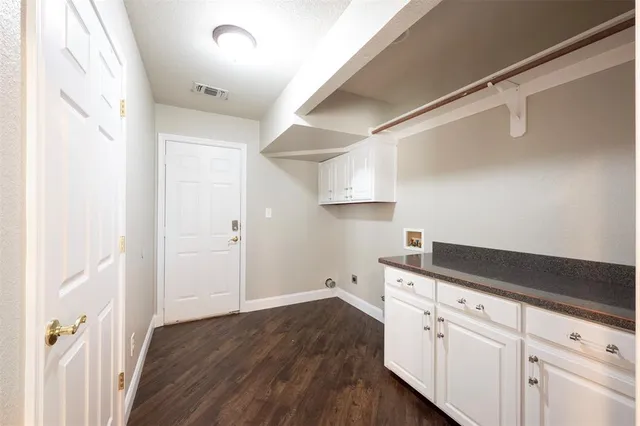 a kitchen with cabinets and wooden floor
