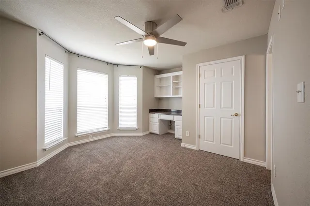 a view of a livingroom with a ceiling fan and window