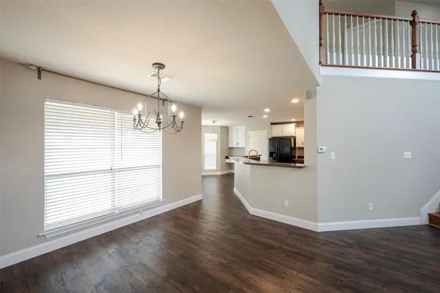 a view of empty room with wooden floor and windows