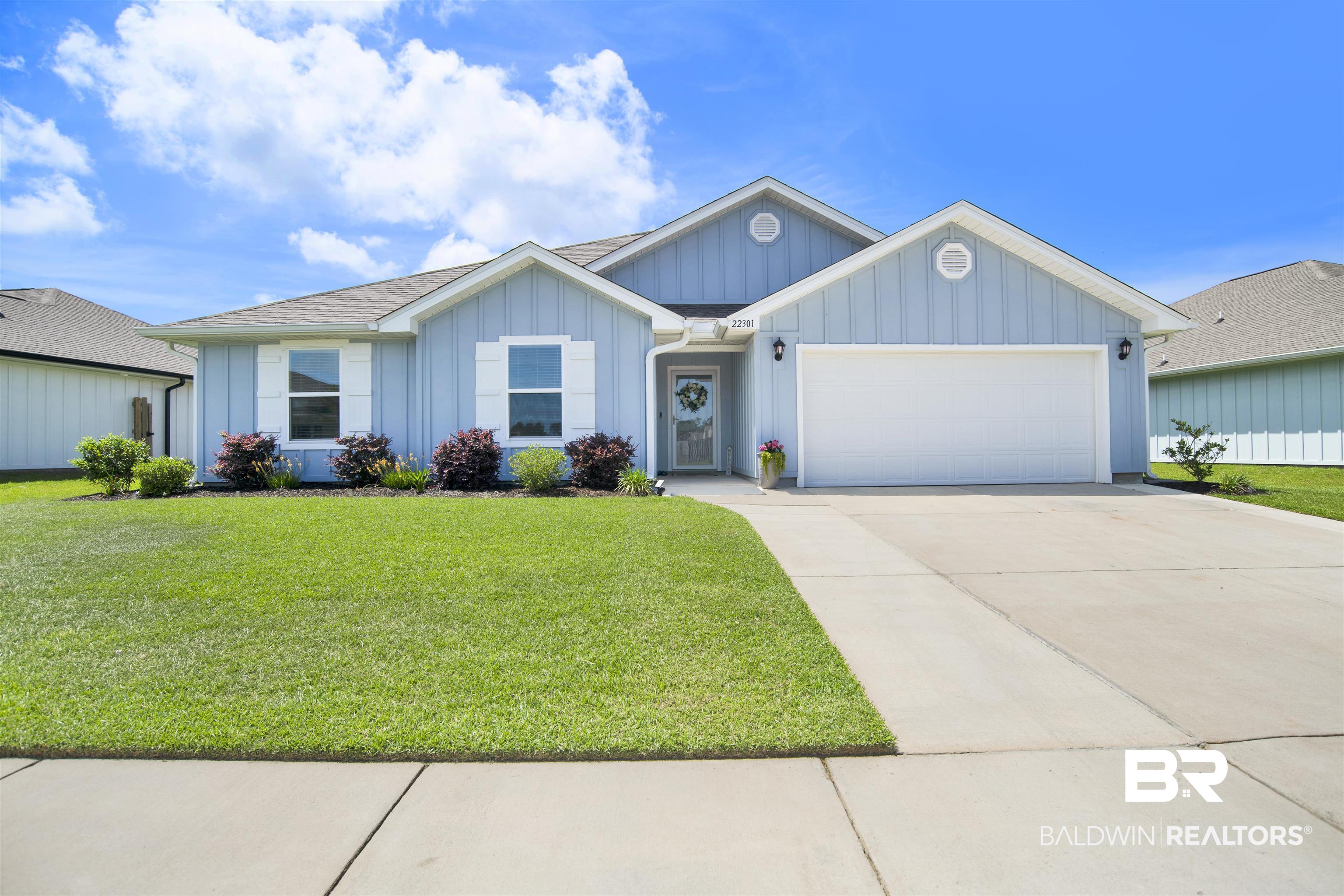 22301 Early Dawn Circle Foley, AL 36535 - Photo 1 of 45 Light blue exterior siding with white trim, a two-car garage, and a concrete driveway