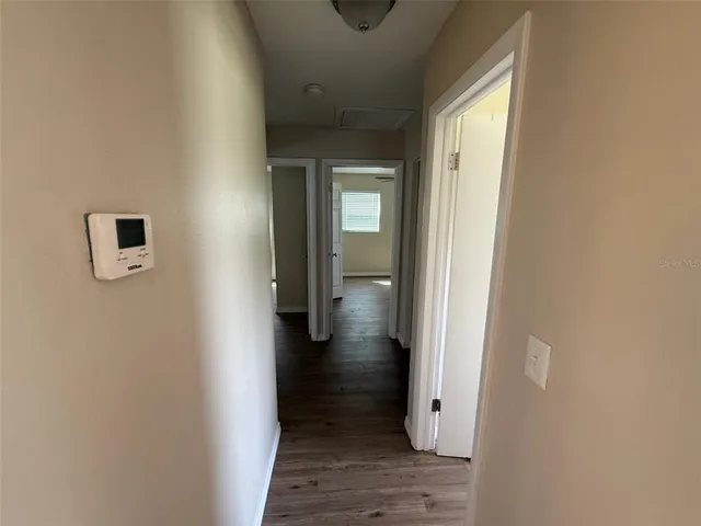 a view of a hallway with wooden floor and closet