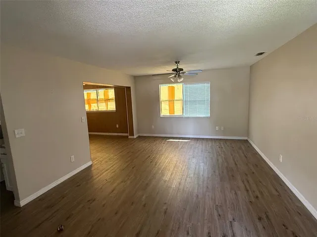 an empty room with a windows and wooden floor