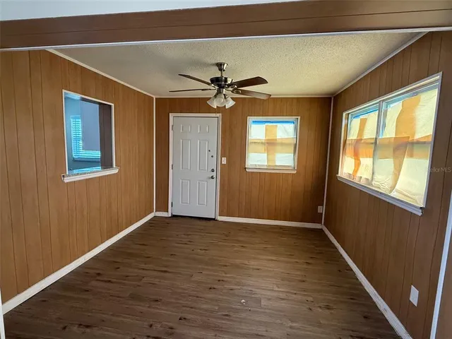 a view of an empty room with a window and a chandelier
