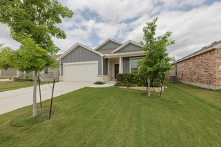 Contemporary exterior featuring gray siding, stone accents, and a white garage door