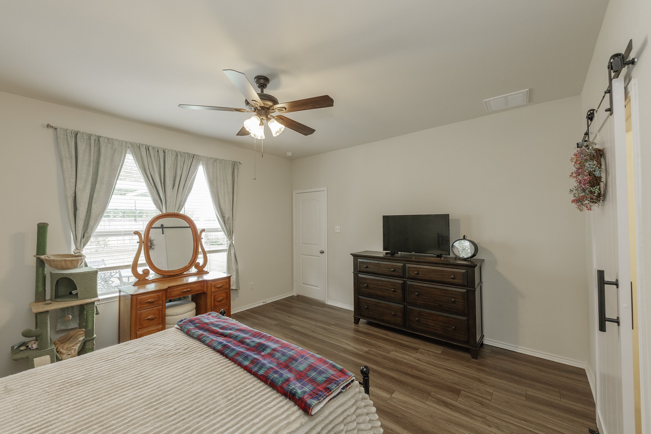 125 Janice Road Taylor, TX 76574 - Photo 13 of 26 Bedroom featuring wood-finish flooring, a ceiling fan with integrated lighting, and neutral wall tones