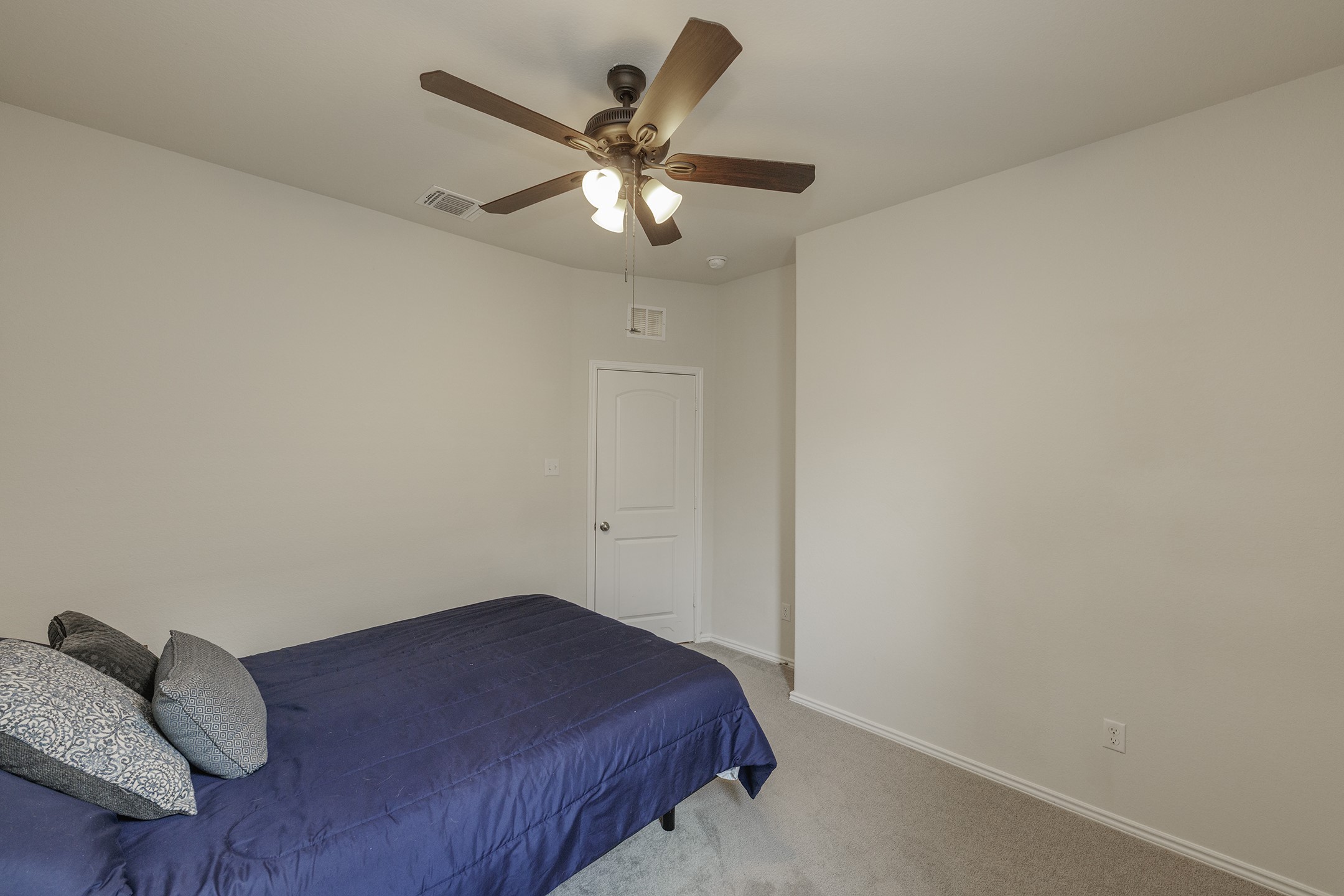 125 Janice Road Taylor, TX 76574 - Photo 16 of 26 Neutral wall paint throughout a carpeted room featuring a ceiling fan with light fixture