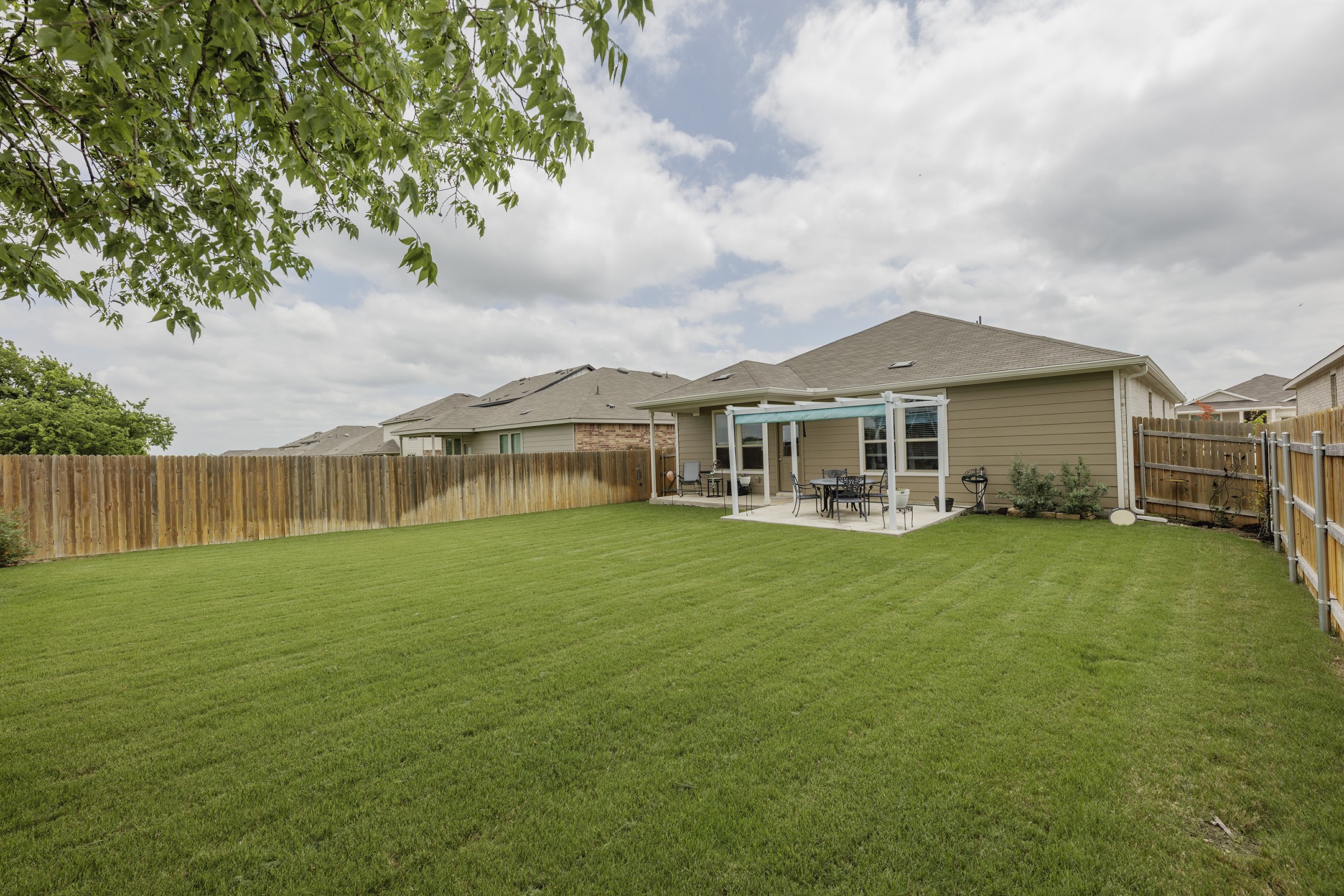 125 Janice Road Taylor, TX 76574 - Photo 26 of 26 Expansive backyard featuring a lush lawn and a wood privacy fence