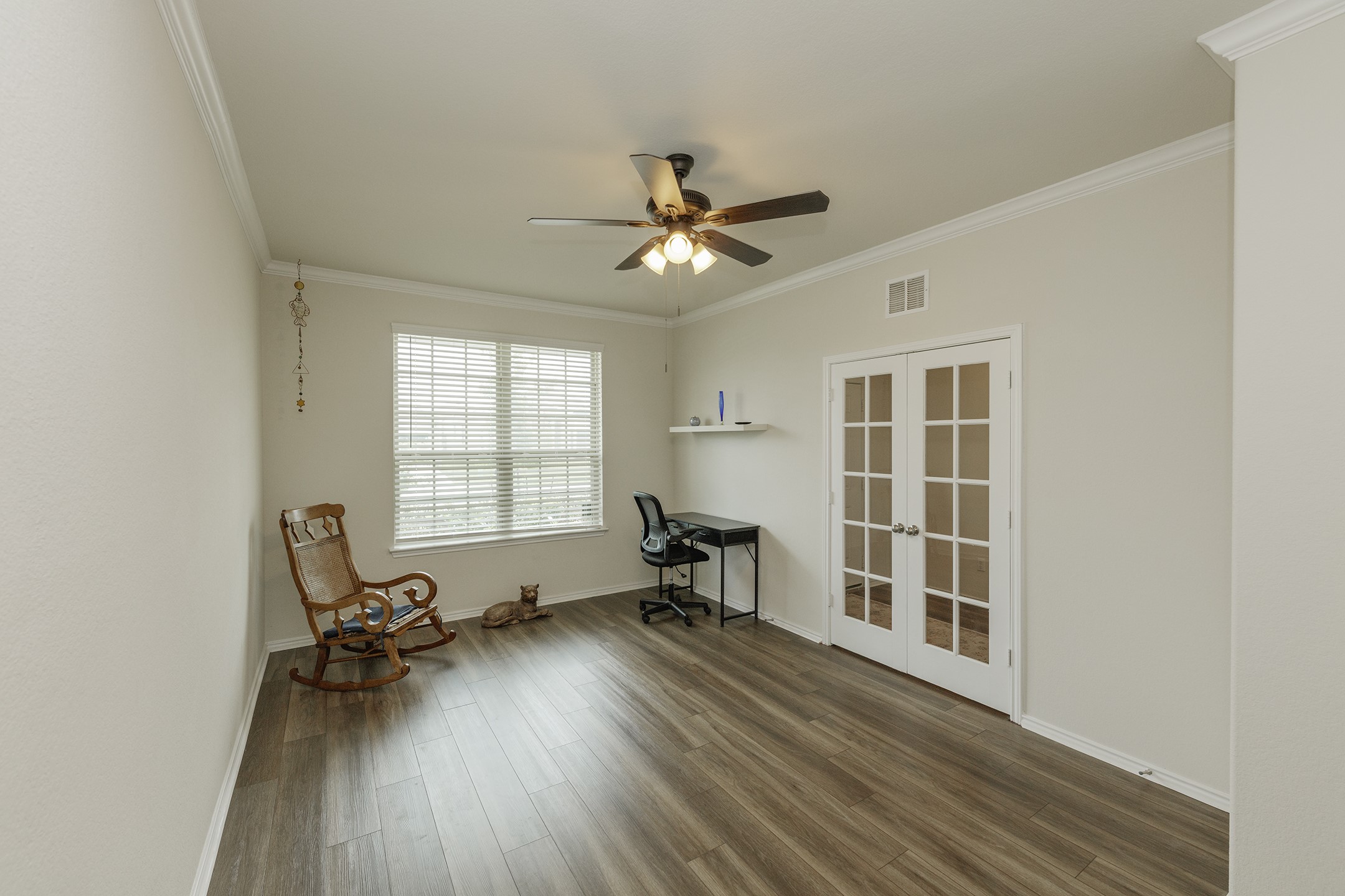 125 Janice Road Taylor, TX 76574 - Photo 9 of 26 Spacious room featuring wood-finish flooring, white crown molding, a ceiling fan with integrated lighting, and a large window with blinds