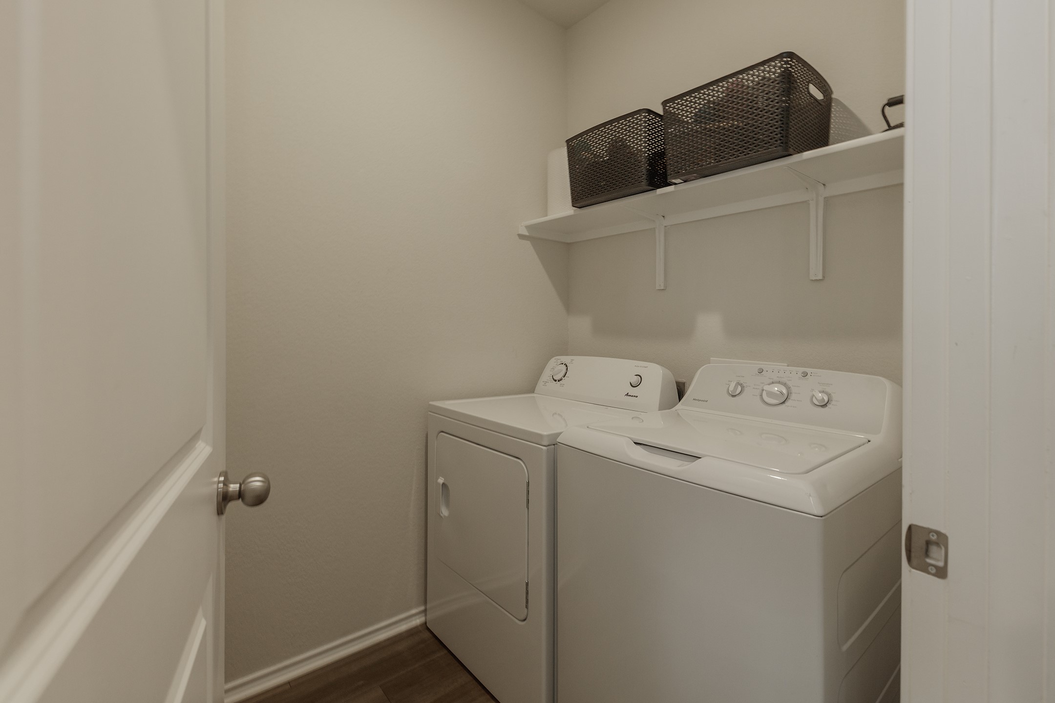 125 Janice Road Taylor, TX 76574 - Photo 10 of 26 Dedicated laundry area featuring a washer and dryer, an overhead storage shelf, and wood-finish flooring