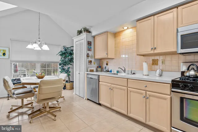 a kitchen with cabinets table and chairs