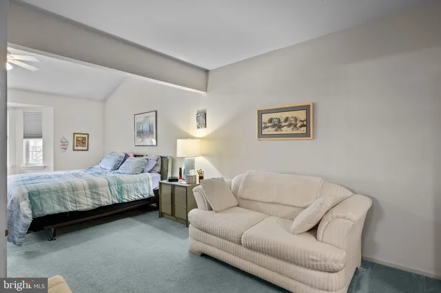 a spacious bedroom with a bed couch and window