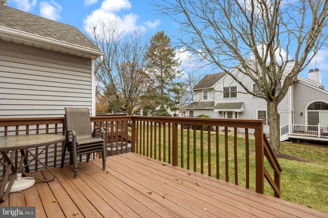 a view of balcony with wooden floor and fence and a bench