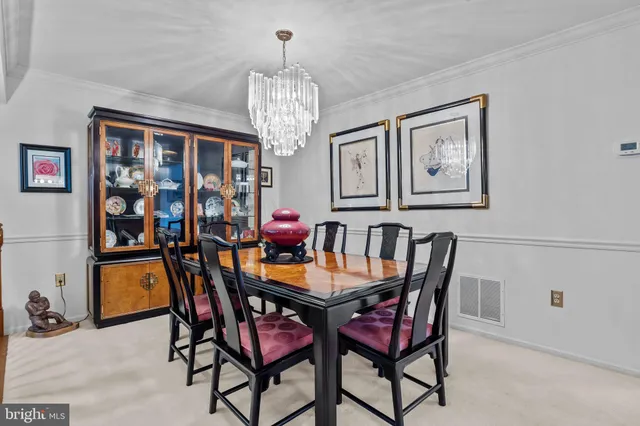 a view of a dining room with furniture a chandelier and window